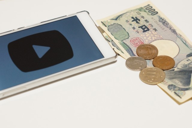 YouTubeを表示しているスマートフォンとお金